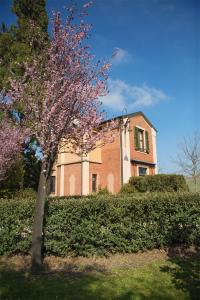 um edifício com uma árvore em frente em La Casina em Casteggio