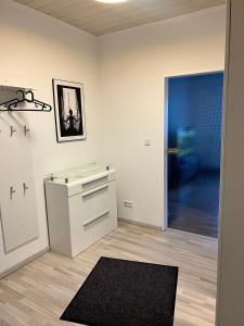 a kitchen with a white cabinet and a blue door at Kurstadt Apartment 2ZKB Balkon PKW Stlp-Self-Check-in in Bad Nauheim