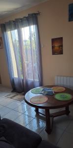 a living room with a table and a window at En plein cœur de l’Île d'Oléron, suite parentale. in Dolus d'Oléron