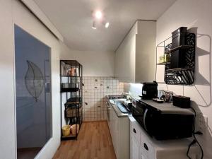 a kitchen with white cabinets and a black appliance at Lovely 2 Bedrooms Apartment in Davos Platz, Davos in Davos