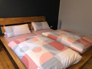 łóżko z kolorową kołdrą i 2 poduszkami w obiekcie Zentrale Unterkunft in Dortmund City w Dortmundzie
