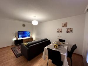 ein Wohnzimmer mit einem Sofa und einem Tisch in der Unterkunft Lovely 2 Bedrooms Apartment in Davos Platz, Davos in Davos