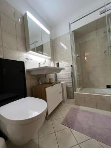 a bathroom with a toilet and a sink and a shower at Lovely 2 Bedrooms Apartment in Davos Platz, Davos in Davos