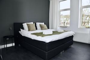 a large bed in a room with two windows at Villa Aix in Kerkrade