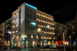 Wysoki biały budynek z zielonym znakiem w obiekcie SQUARE APARTMENTS GDYNIA w mieście Gdynia