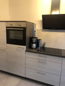 a kitchen with white cabinets and a black oven at Zentrale Unterkunft in Dortmund City in Dortmund