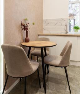 a table and chairs in a kitchen with a vase on it at Royal Art-apartment on Chaikovskogo 26 in Lviv