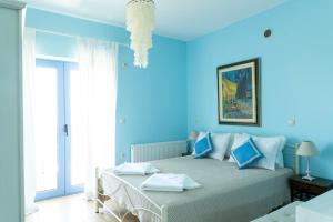 a blue bedroom with a bed with blue walls at VILLA HORIZON, PORTIANOU in Pedhinón