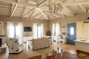 a living room with white furniture and a coffered ceiling at VILLA HORIZON, PORTIANOU in Pedhinón