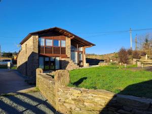 a house with a stone fence in front of it at Casa Mathias in O Pino 