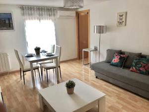 uma sala de estar com um sofá e uma mesa em Apartamento Ramon Pignatelli em Zaragoza