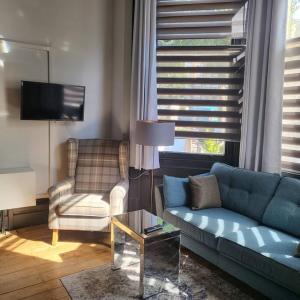 a living room with a blue couch and a chair at 21 Mini Loft Apartment - Great Location - Comfy King Size Bed in Brighton & Hove