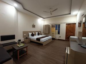 um quarto de hotel com uma cama e uma televisão em Hotel Padmini International- Sigra em Kakarmatha