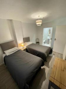 1 dormitorio con 2 camas, mesa y ventana en Top Twenty Bed and Breakfast en Windsor