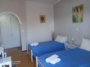2 Betten in einem Zimmer mit blauer Bettwäsche in der Unterkunft Dimitris Apartments Messongi in Mesongi