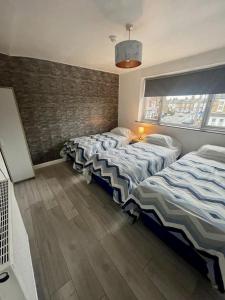 1 dormitorio con 2 camas y ventana en Top Twenty Bed and Breakfast en Windsor