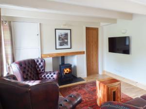 uma sala de estar com duas cadeiras e uma lareira em Spring Garden Cottage em Carmarthen