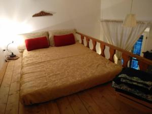 uma cama com duas almofadas vermelhas num quarto em Nel Bel Mezzo di Pisa em Pisa
