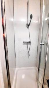 a shower with a glass door and a sink at Burford Road - Stay. Sleep. Rest. in Nottingham