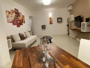 un salon avec un verre de vin sur une table en bois dans l'établissement Apartma Sova Koper, à Koper