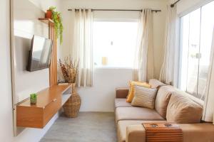 a living room with a couch and a tv at Casa Mar do Patacho in Pôrto de Pedras