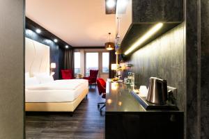 ein Hotelzimmer mit einem Bett und einer Küche mit einer Theke in der Unterkunft PLAZA Premium Schwerin Sure Hotel Collection by Best Western in Schwerin