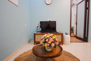 a living room with a vase of flowers on a table at Phuong Tran Apartment and Hotel in Danang