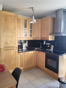 a kitchen with wooden cabinets and a black appliance at Nice garden in Nice
