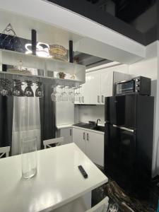 cocina con mesa blanca y nevera negra en Apartament 105 - HF Building Resort, en Mamaia Nord – Năvodari