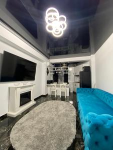 sala de estar con sofá azul y TV en Apartament 105 - HF Building Resort, en Mamaia Nord – Năvodari