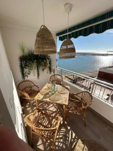 stół i krzesła na balkonie z widokiem na wodę w obiekcie Apartamento Antonio with sea view,Torrevieja,50 m from Playa Acequion plus swimming pool w mieście Torrevieja