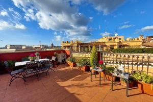 a patio with tables and chairs on a balcony at Spagna Penthouse in Rome