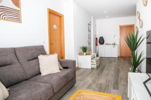 a living room with a gray couch and a hallway at O Cardanho dos Galfarritos - A Casa dos Miúdos in Aveiro