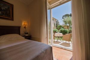 a bedroom with a bed and a balcony with a table at Amadria Park Hotel Agava in Opatija