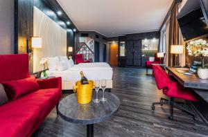 um quarto de hotel com uma cama e mobiliário vermelho em PLAZA Premium Schwerin Sure Hotel Collection by Best Western em Schwerin