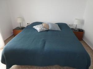 a bed with a blue comforter in a bedroom at Thalassa Villa in Plakias