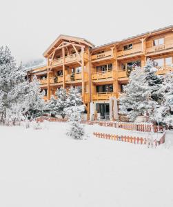 a lodge in the snow with snow covered trees at Hôtel Chalet Mounier in Les Deux Alpes