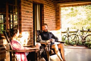 a man and a girl sitting at a table with a cup of coffee at iNsingizi Lodge in Mid Illovo
