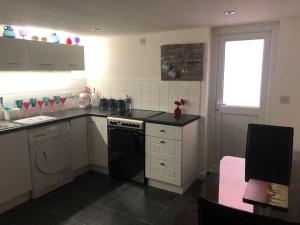 a kitchen with a sink and a stove top oven at The Old Laundry in Rye