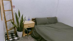 a bedroom with a bed and a desk with a plant at Rot Homestay in Da Lat