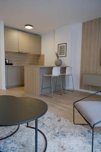 a living room with a table and a kitchen at Aparthotel Cosy in Stuttgart