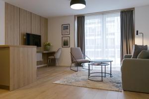ein Wohnzimmer mit einem Sofa, einem Tisch und einem TV in der Unterkunft Aparthotel Cosy in Stuttgart