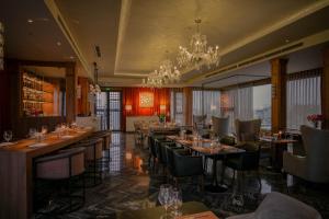 a restaurant with tables and chairs and a chandelier at Le Jardin Hotel Haute Couture in Hanoi +103 photos