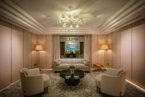 a living room with a couch and a table and chairs at Le Jardin Hotel Haute Couture in Hanoi