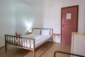 a bedroom with a bed and a red door at John's Guesthouse in Ksamil