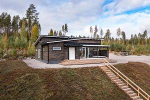 a small cabin with a porch on a field at Villa Kannas 1 in Juuka