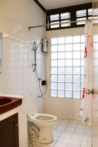 een badkamer met een douche, een toilet en een wastafel bij Bed By Cruise Hotel At Samakkhi-Tivanont in Nonthaburi