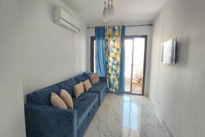 - un salon avec un canapé bleu et une fenêtre dans l'établissement شاليه للايجار اليومى بورتو سعيد, à Port-Saïd