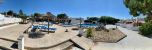 a courtyard with a pool with blue lounge chairs at Villas Estrellas 11 in Ciutadella +18 photos