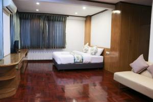 um quarto com uma cama, uma televisão e um sofá em Bed By Cruise Hotel At Samakkhi-Tivanont em Nonthaburi